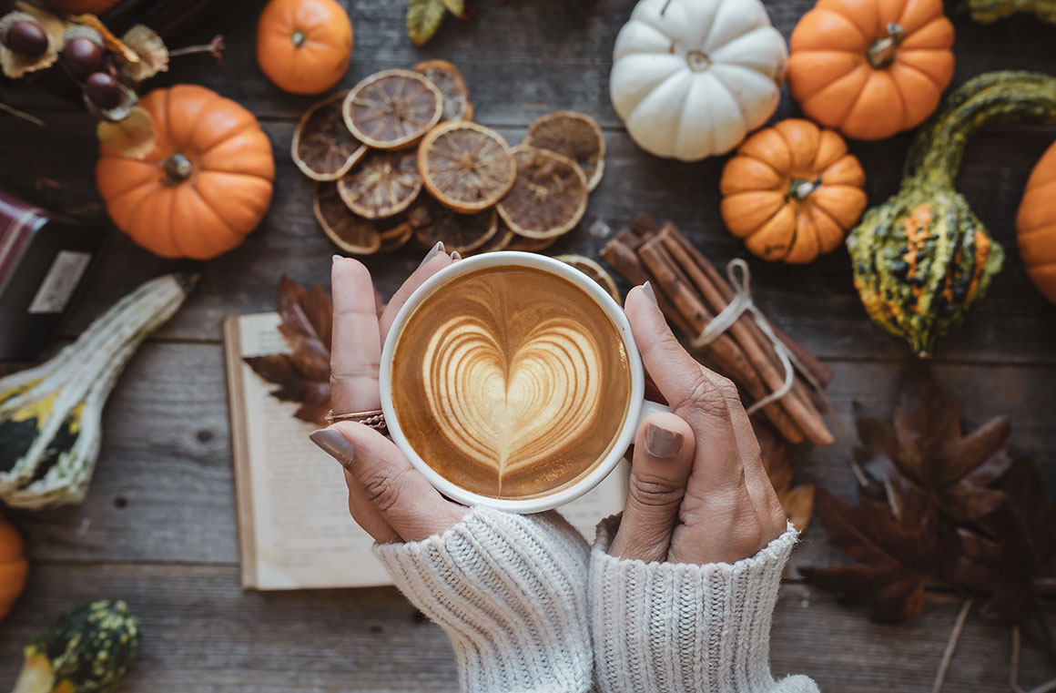 women holding coffee over fall decorated table