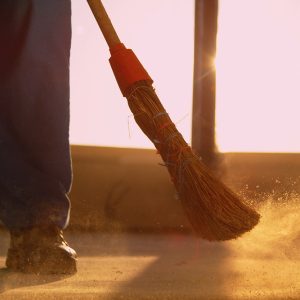 man sweeping dirt