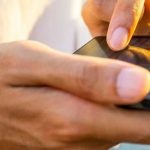 Close up of a mans hands using a smartphone